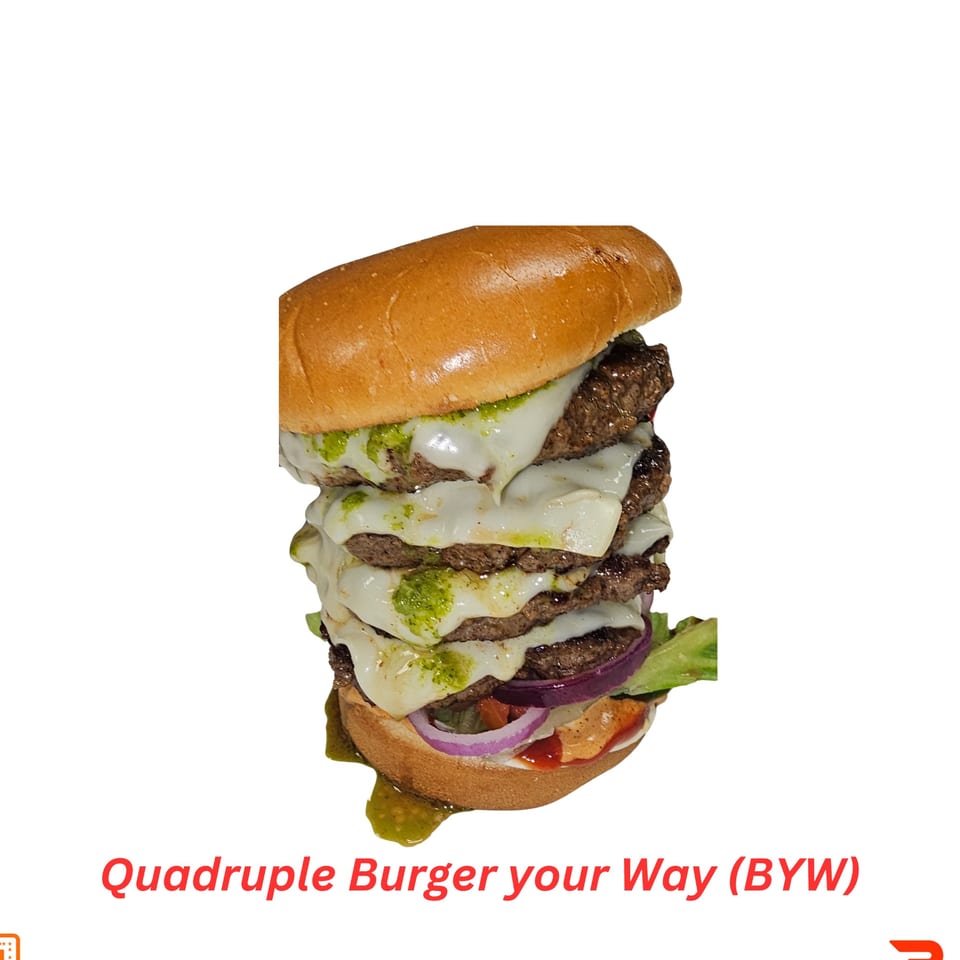 A towering quadruple halal burger with melted cheese, green sauce, red onions, and lettuce.