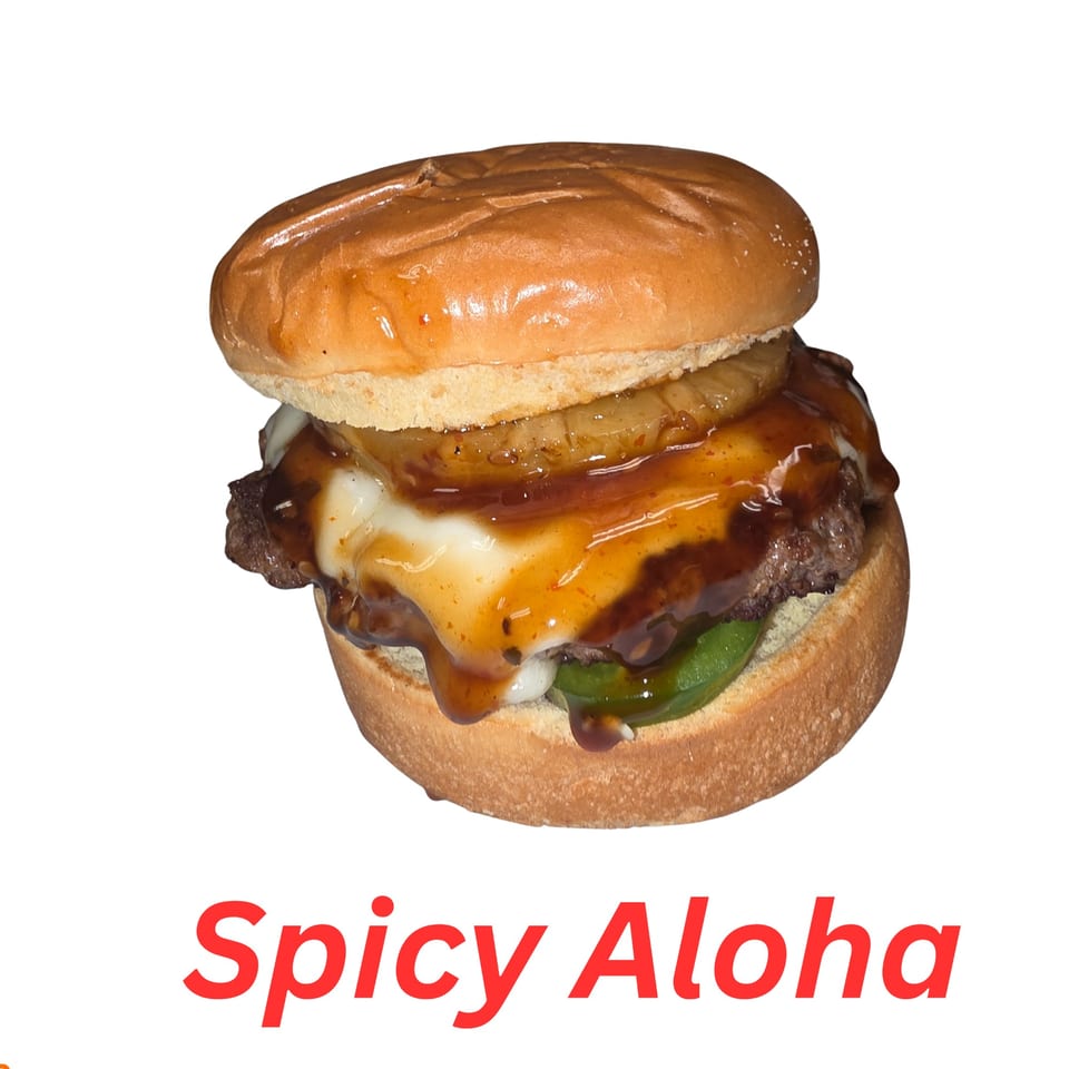 A halal burger with pineapple, melted cheese, and dark sauce on a bun.