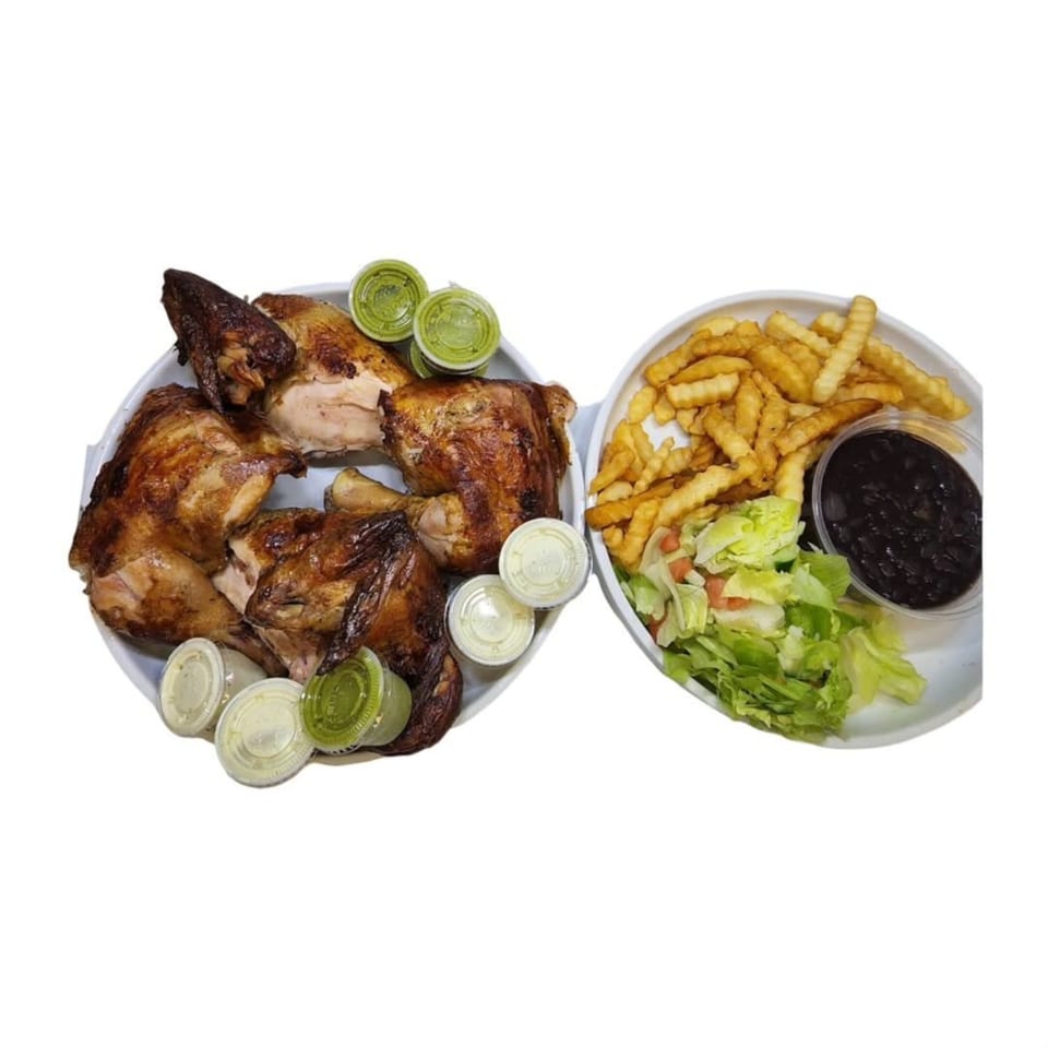 Halal roasted chicken with green and white sauces, crinkle-cut fries, black beans, and salad.