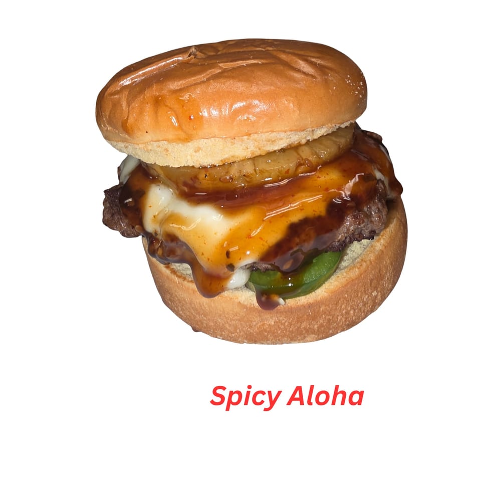 A "Spicy Aloha" halal burger with pineapple, melted cheese, and sauce on a bun.