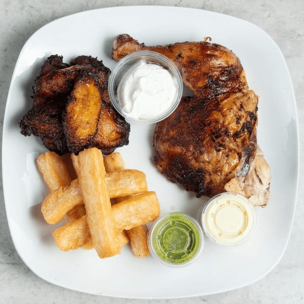 Halal Boyz grilled chicken, fried plantains, yucca fries, and three sauces on a white plate.
